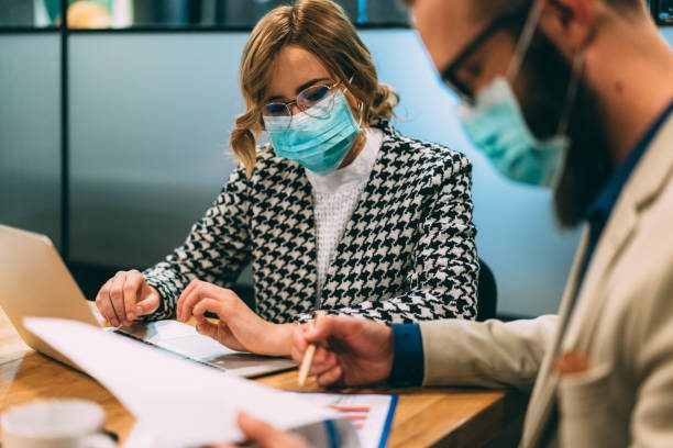 Businesspeople wearing masks in the office for safety during COVID-19 pandemic