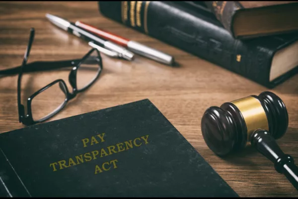 Law book on a desk that reads pay transparency act to explain California Pay Data Reporting